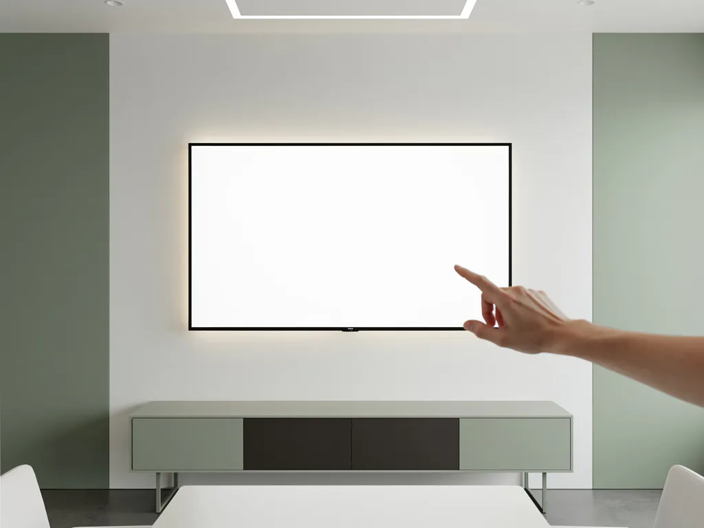 Hand die een 90-inch interactief touchscreen aanraakt in een minimalistische vergaderruimte met salie groene en antraciet tinten.